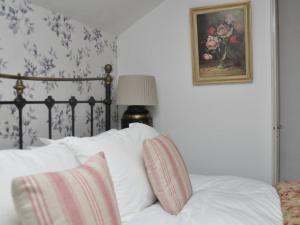 a bed with white pillows and a picture on the wall at 2 Bed in Chipping Norton oc-73904 in Swerford