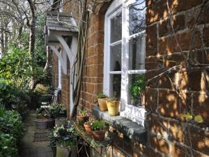 a window of a brick house with potted plants on it at 2 Bed in Chipping Norton oc-73904 in Swerford