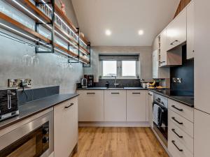 a kitchen with white cabinets and stainless steel appliances at 2 Bed in Castle Douglas oc-59637 in Castle Douglas +11 photos