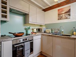 a kitchen with white cabinets and a stove top oven at 2 Bed in Carnforth oc-90530 in Beetham +17 photos