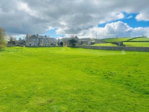 a large green field with a house in the background at 2 Bed in Carnforth oc-90530 in Beetham