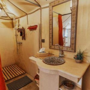 a bathroom with a sink and a shower with a mirror at Overnight Luxury Camp in Merzouga +63 photos