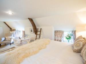 a large white bed in a room with a table at 3 Bed in Bath oc-skn21 in Wellow
