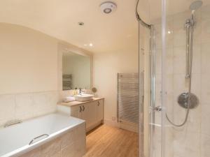 a bathroom with a tub and a sink and a shower at 3 Bed in Bath oc-skn21 in Wellow