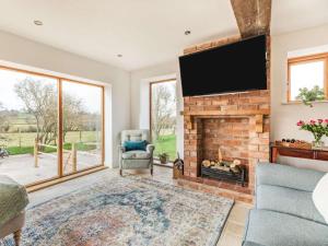 a living room with a fireplace and a flat screen tv at 3 Bed in Pershore oc-86760 in Eckington