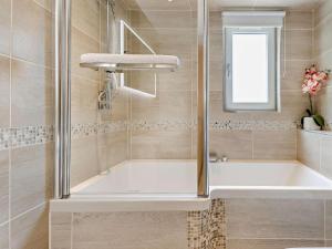 a bathroom with a tub and a shower with a window at 2 Bed in Castle Douglas oc-59638 in Castle Douglas