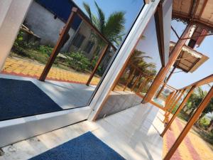 an open door to a house with a palm tree at Sheoak Retreat Tajpur in Tajpur
