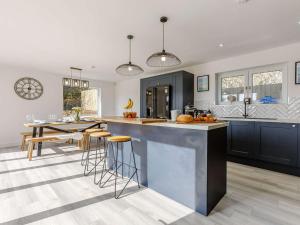 a kitchen with a large island with bar stools at 4 Bed in Holsworthy oc-85673 in Bridgerule