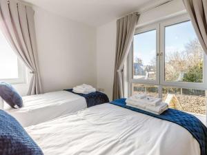 two beds in a room with a window at 4 Bed in Holsworthy oc-85673 in Bridgerule