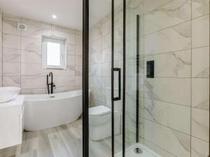 a bathroom with a tub and a toilet and a sink at 4 Bed in Holsworthy oc-85673 in Bridgerule +41 photos