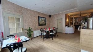 a room with a table and chairs and a kitchen at Pension Zum Lukullus in Wernigerode