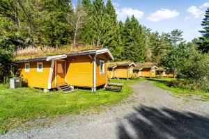 a row of small yellow cabins in a forest at Fosseland Hytter in Feda