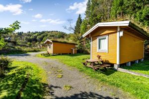 a cabin and a picnic table next to a gravel road at Fosseland Hytter in Feda