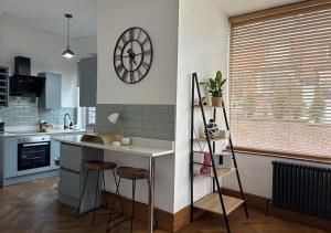 a kitchen with a counter and a clock on the wall at Stylish 1-Bedroom Apartment in Chapel Allerton with Free Parking in Moortown