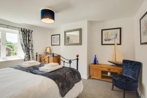 a bedroom with a bed and a chair and a desk at 3 Bed in Brancaster oc-2153 in Brancaster