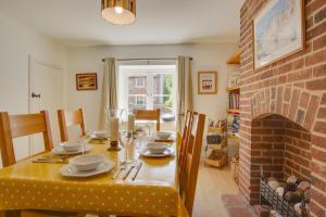 a dining room with a table and a fireplace at 3 Bed in Brancaster oc-2153 in Brancaster +9 photos