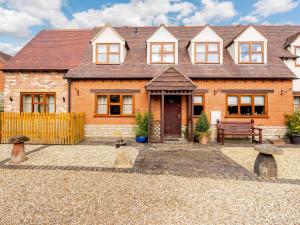 a brick house with a bench in front of it at 3 Bed in Evesham oc-89477 in Bretforton