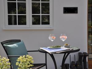 a table and chair with a plate of food and wine glasses at 1 Bed in Banbury oc-57103 in Upper Brailes +2 photos