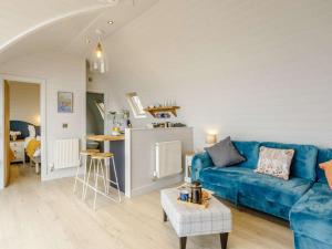 a living room with a blue couch and a table at 2 Bed in Tain oc-81340 in Nigg +11 photos
