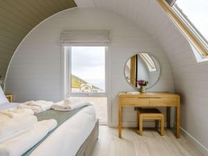 a bedroom with a bed and a mirror and a table at 2 Bed in Tain oc-81340 in Nigg
