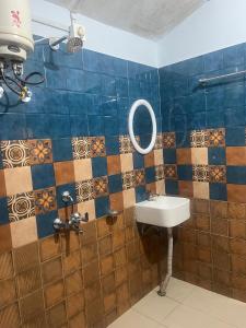 a bathroom with a sink and a mirror on the wall at Org Retreat & Farmstay in Guwahati