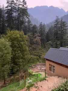 a small house in the middle of a forest at Riverside Mudhouse Duplex Cottage by Kahani in Jibhi