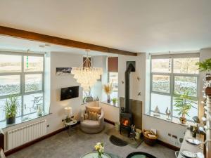 a living room with a chandelier and a chair and windows at 1 Bed in Carnforth oc-90528 in Beetham