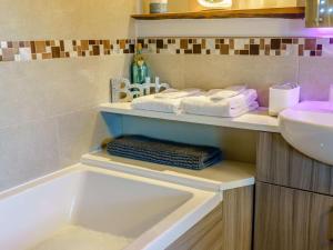 a bathroom with a tub and a sink and towels at 1 Bed in Carnforth oc-90528 in Beetham +15 photos