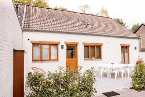 a white house with a table and chairs at Le Louis Vakantiehuis in Lanaken