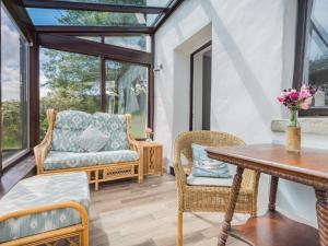 a conservatory with a table and chairs and a wooden floor at 4 Bed in Broughton-in-furness oc-sz183 in Ulpha