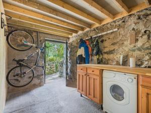a bike hanging on the wall of a kitchen with a washing machine at 4 Bed in Broughton-in-furness oc-sz183 in Ulpha