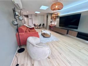 a living room with a red couch and a table at Charmant appartement plain-pied avec accès facile in Bailleul
