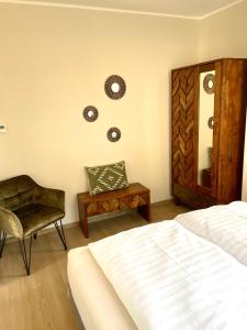 a bedroom with a bed and a chair and a mirror at Apartments Aura & Nova in Aue-Bad Schlema