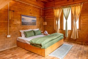 a bedroom with a bed in a wooden room at Riverside Mudhouse Duplex Cottage by Kahani in Jibhi