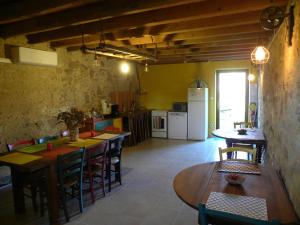 a kitchen and dining room with tables and chairs at Chambres d'hôtes Les cabris in Verneix