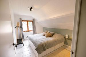 a bedroom with a bed and a window at Le Louis Vakantiehuis in Lanaken