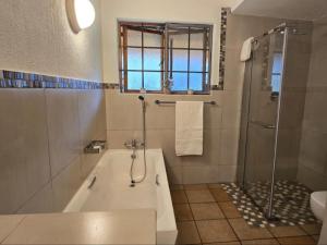 a bathroom with a tub and a shower and a sink at Kruger park lodge 517 in Hazyview