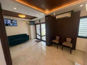 a waiting room with a green couch and two chairs at Hotel Royal Luxe - US consulate, Apollo hospital, Sankara natralya in Chennai