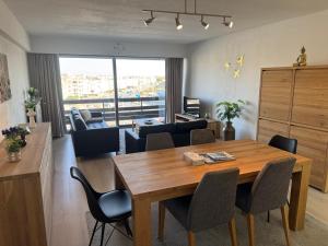 a living room with a wooden table and chairs at Casa Ghentele in Blankenberge