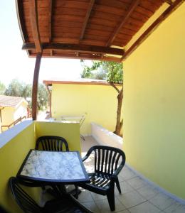a patio with two chairs and a table on a balcony at Villaggio Santo Stefano in Vieste