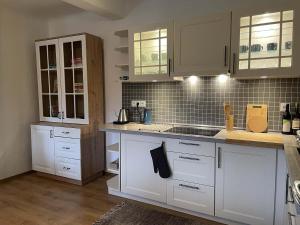 a kitchen with white cabinets and a counter top at Chalupa Lindenberg in Jestrabi V Krkonosich