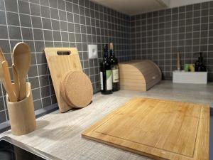 a kitchen counter with wooden cutting boards and bottles of wine at Chalupa Lindenberg in Jestrabi V Krkonosich