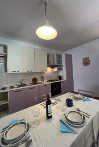 a kitchen with a table with a bottle of wine on it at Casa FLORE in Orosei