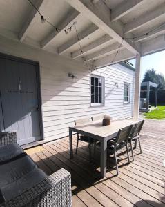 a patio with a table and chairs on a deck at Cottage du Lac Studio in Nivezé