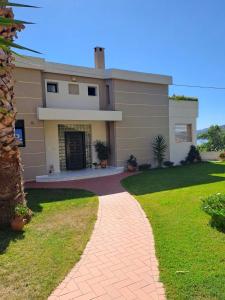a house with a brick walkway in front of it at CRYSTAL BAY in Paleo Tsifliki