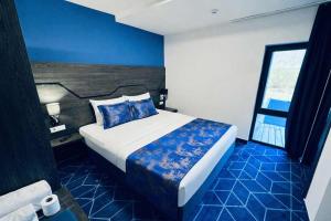 a bedroom with a large bed with a blue floor at Hotel Biga in Zavidovići +48 photos