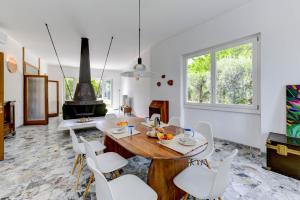 a dining room with a wooden table and white chairs at MGH - Villa Sirmione in Sirmione
