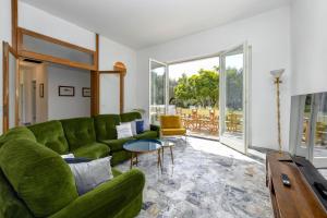 a living room with a green couch and a table at MGH - Villa Sirmione in Sirmione
