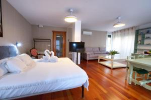a bedroom with a large white bed and a living room at Rual Suites By Cuencaloft in Cuenca +72 photos