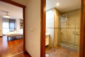 a bathroom with a shower and a bedroom with a bed at Rual Suites By Cuencaloft in Cuenca